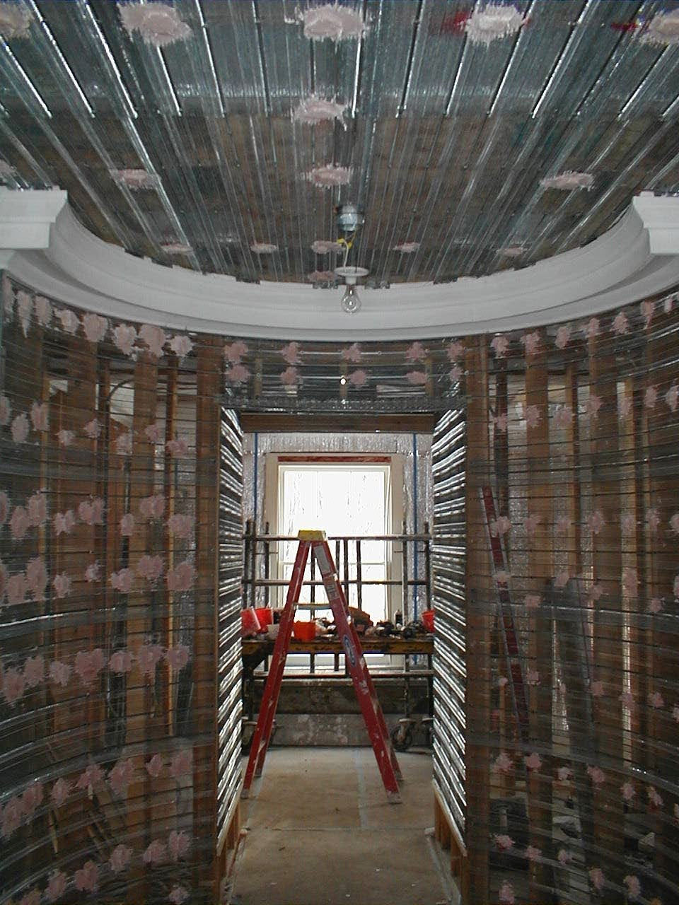 Oval entry hall under construction — metal lath applied to curved walls and domed ceiling